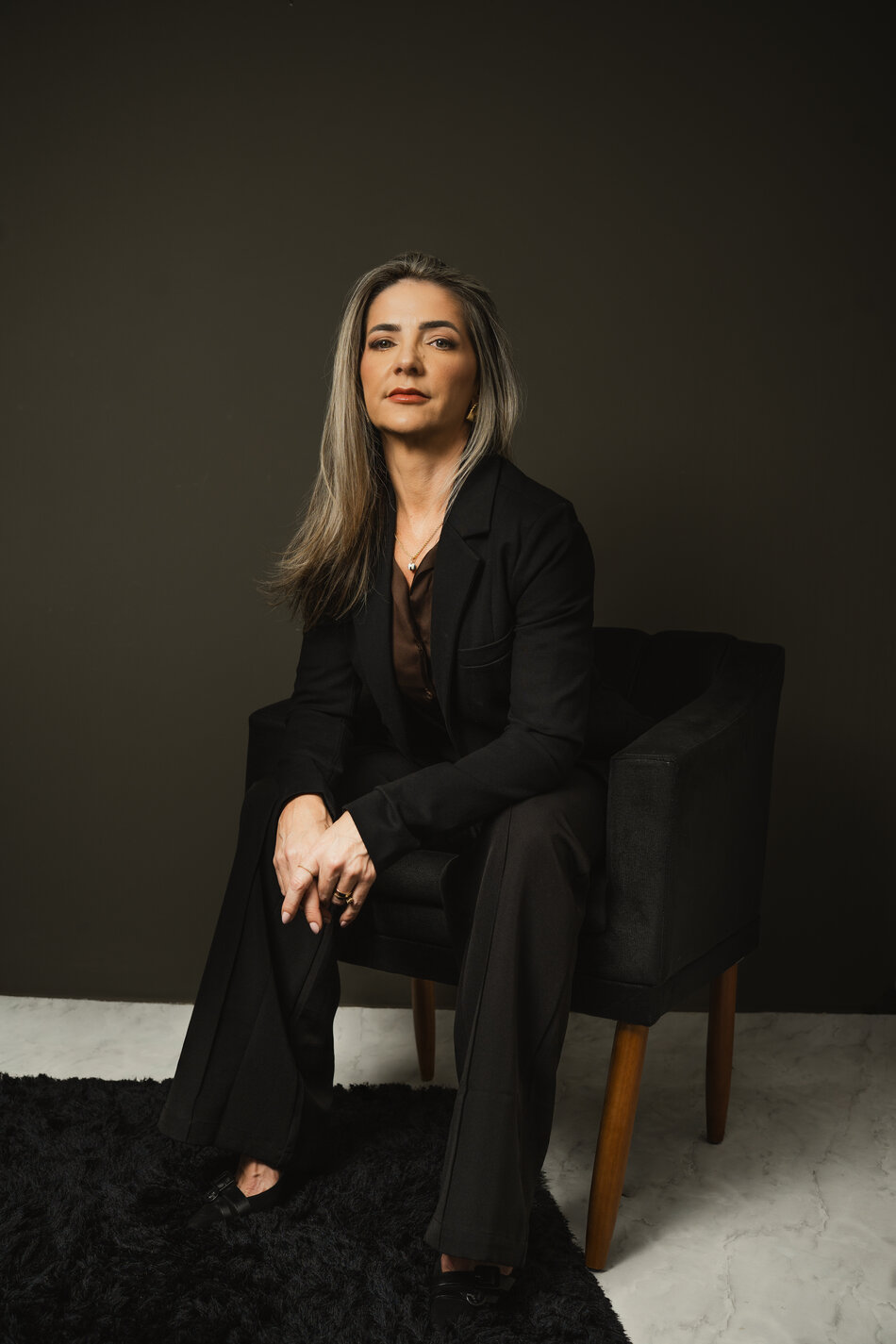 Josimara Veiga Ruiz sentada em poltrona, retrato profissional